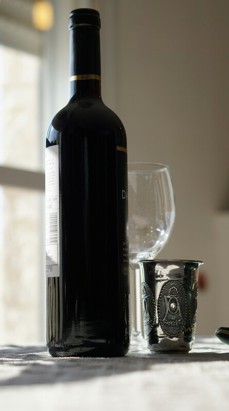 Wine and a silver kiddush cup on a Shabbat table
